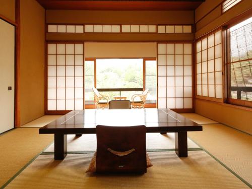 a room with a table and chairs in it at 源泉掛け流しの宿Albergo湯楽 in Yugawara