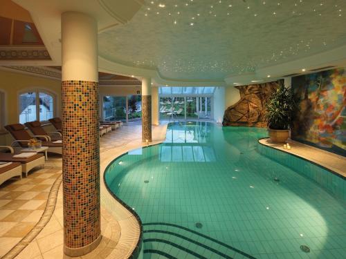 a large swimming pool in a building with a pool at Sonnenhotel Adler Spa & Nature Adults only in Villandro