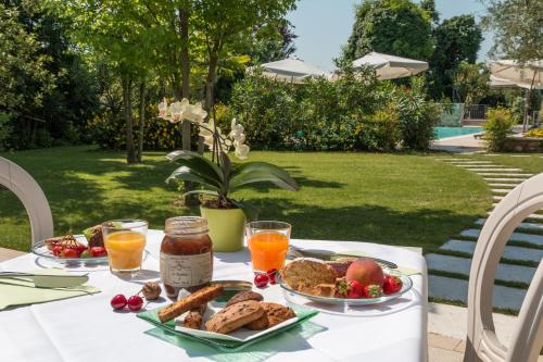 een tafel met een bord eten en sinaasappelsap bij Agriturismo Corte Aurea in Desenzano del Garda