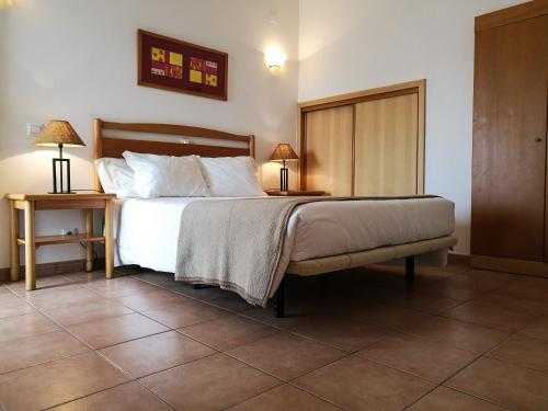 - une chambre avec un lit et 2 tables avec des lampes dans l'établissement Club House CVL, à Luz