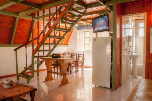 eine Küche mit einer Treppe, einem Tisch und einem Kühlschrank in der Unterkunft Apart Hotel Ensueño in San Martín de los Andes