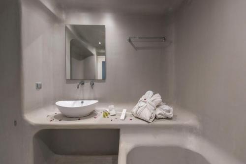 a white bathroom with a sink and a mirror at Blue Waves Suites & Apartments in Kamari
