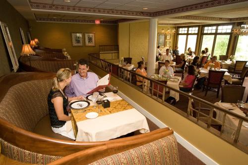 un homme et une femme assis à une table dans un restaurant dans l'établissement Stafford's Perry Hotel, à Petoskey