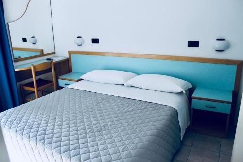a bedroom with a bed with a blue head board at Villa Greta in Santarcangelo di Romagna