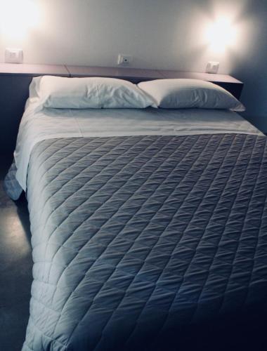 a large bed with white sheets and pillows at Villa Greta in Santarcangelo di Romagna
