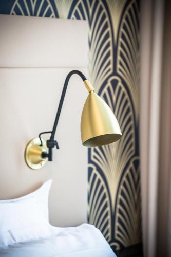 a hotel room with a lamp on a wall at Best Western Hôtel Journel Saint-Laurent-du-Var in Saint-Laurent-du-Var