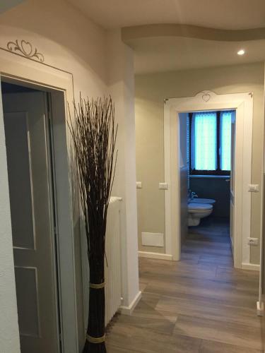 a bathroom with a vase with a tree in it at Villa Giardino - Flowers in Molveno