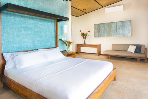 a bedroom with a large bed and a couch at Hotel Three Sixty - Adults Only in Ojochal