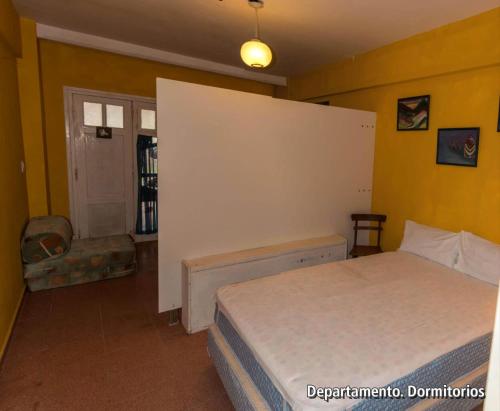 1 dormitorio con 1 cama en una habitación con paredes amarillas en Casablanca del Mar en Santa Clara del Mar