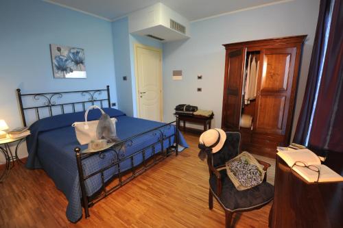 a bedroom with a blue bed and a chair at Villa Vecchio in Castagnito