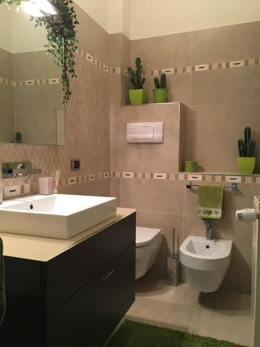 Un baño con lavabo, inodoro y espejo. en Clorofilla, en Desenzano del Garda