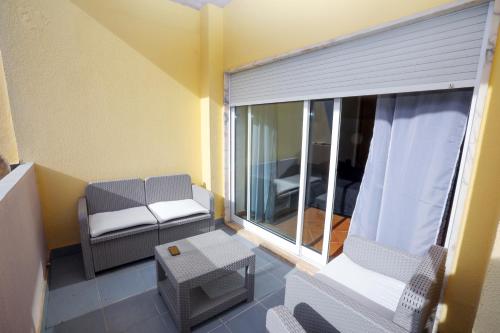 ラゴスにあるConfortável T2 Meia Praiaのバルコニー(椅子付)、窓が備わる客室です。
