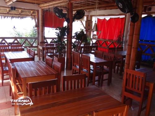 an empty restaurant with wooden tables and chairs at Tayrona Dive Center in Taganga