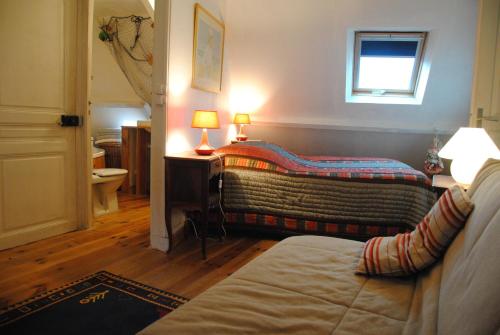 a bedroom with two beds and a window at Chambres Chez Mounie in Arromanches-les-Bains