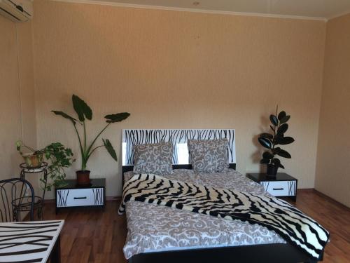 - une chambre avec un lit et deux tables avec des plantes dans l'établissement Апартаменты, à Izmaïl