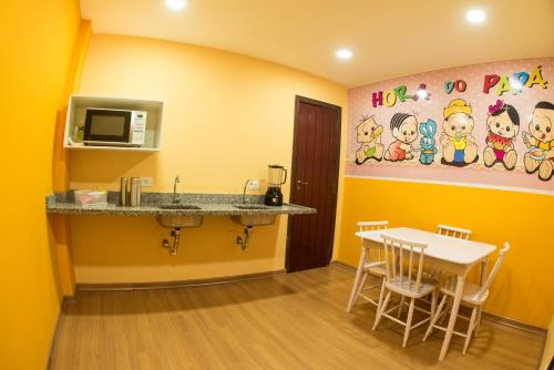 a dining room with a table and a microwave at Hotel Matsubara in Campos do Jordão