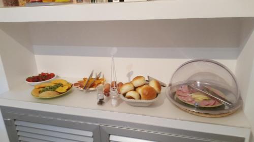 a counter with plates of food and bowls of fruit at Il Vicolo B&B in Milazzo
