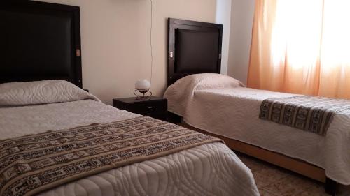 Habitación de hotel con 2 camas y ventana en Del Cangrejo 1089 en Pinamar