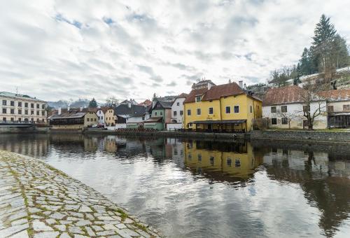a group of buildings next to a river at Babylon Apartmány in Český Krumlov
