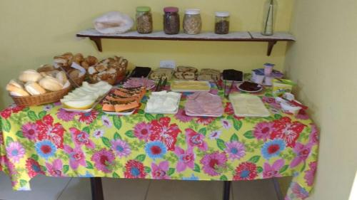une table contenant de la nourriture et d'autres articles dans l'établissement Pousada Villa Itália - Itaúna Saquarema, à Saquarema