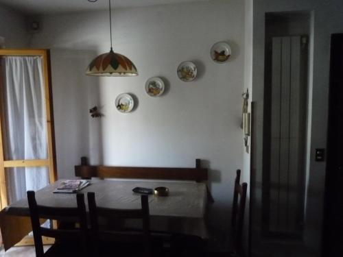 comedor con mesa, sillas y lámpara en Casa Corone, en Alfedena