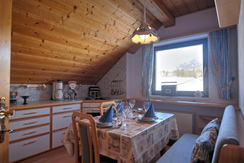 une cuisine avec une table et une grande fenêtre dans l'établissement Haus Regenbogen, à Mariapfarr