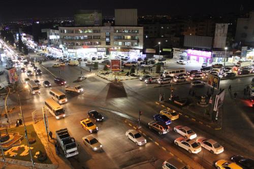 a busy city street at night with alot of cars at Sara Crown Hotel in Irbid