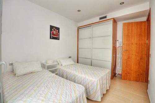 リョレート・デ・マルにあるApartment Jordiのベッドルーム1室(ベッド2台、クローゼット付)