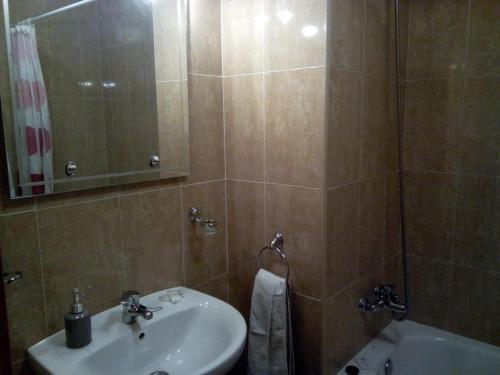 a bathroom with a sink and a mirror and a tub at Hostal Catalina de Austria in Torquemada