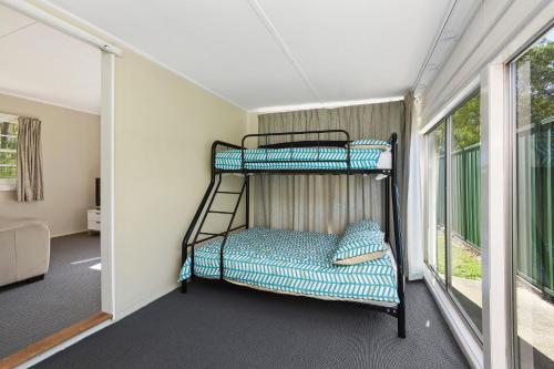 two bunk beds in a room with a balcony at Diamond Waters Caravan Park in Dunbogan