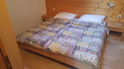 a bed with a quilt on it in a bedroom at Rogla app Jerebika 11 in Zreče