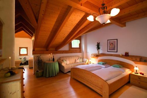 um quarto grande com uma cama grande e um sofá em Berglandhotel Untertheimerhof em Villandro