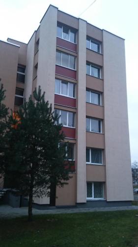 un edificio de apartamentos con un árbol delante de él en Čiurlionio 83 Druskininkai en Druskininkai