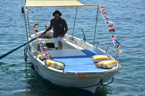 a man standing on a boat in the water at Il Vicolo B&B in Milazzo