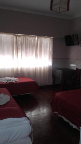 Habitación de hotel con 2 camas y ventana en Posada La Casona en Salta