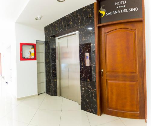 a elevator in a building with a wooden door at Hotel Sabana del Sinu By GEH Suites in Montería