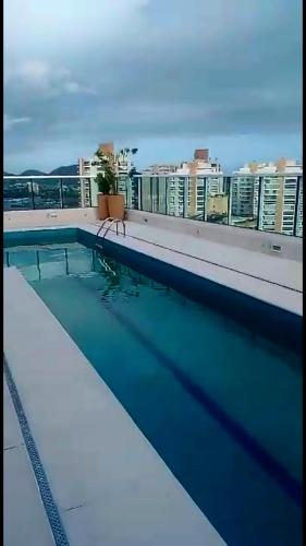 a swimming pool on the roof of a building at Studio mobiliado in Santos