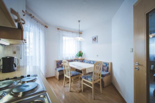a kitchen with a table and chairs and a stove at Garni Appartement Alpenresidence in Cadipietra