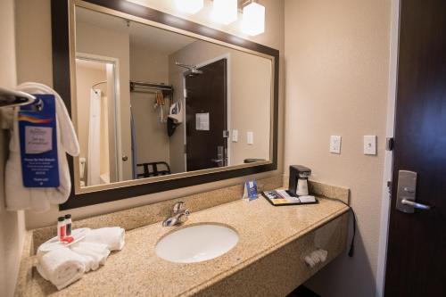 a bathroom with a sink and a large mirror at Baymont by Wyndham Detroit Airport/Romulus in Romulus