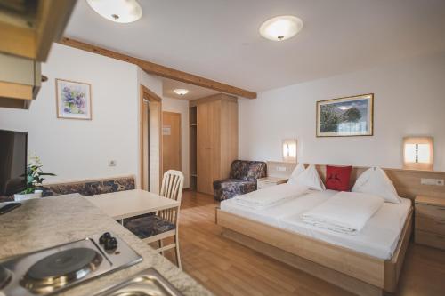 una camera d'albergo con letto e cucina di Garni Appartement Alpenresidence a Cadipietra