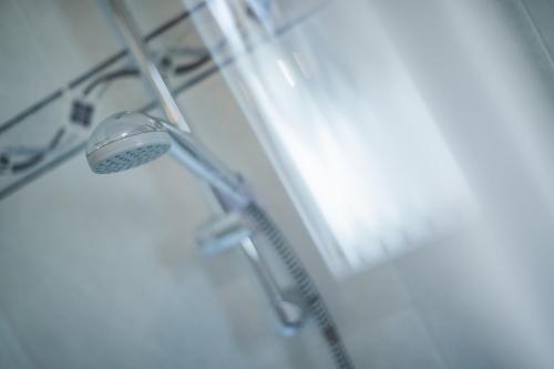 a shower with a shower head in a bathroom at Garni Appartement Alpenresidence in Cadipietra
