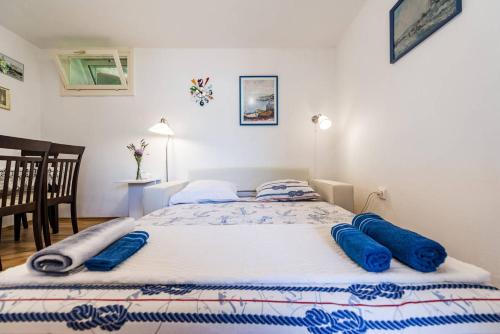 a bedroom with a bed with blue pillows on it at Apartment Pjaca in Postira