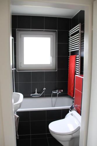 a bathroom with a tub and a toilet and a sink at Gais Alpins in Montreux
