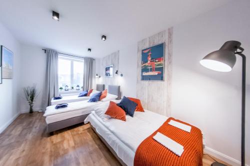 ein Schlafzimmer mit zwei Betten und einem großen Fenster in der Unterkunft Family Luxury Comfort Old Town Apartament, 1-8, 2 sypialnie i salon, parking w cenie, SUMMERWINTER Brand in Danzig