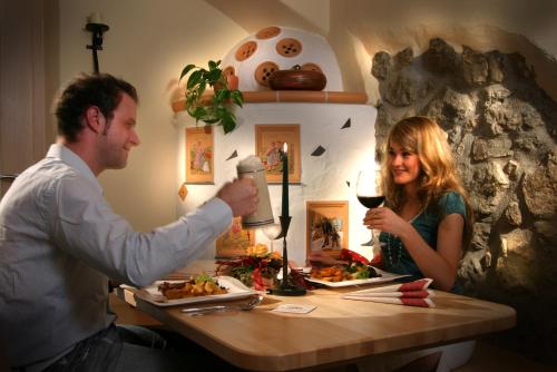 a man and woman sitting at a table with food at Landgasthof Reichsadler in Höchstädt bei Thiersheim