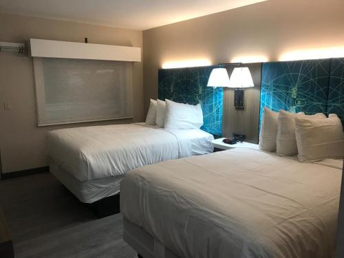 ein Hotelzimmer mit 2 Betten und 2 Lampen in der Unterkunft Oasis Inn in Beaufort