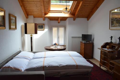 ein Schlafzimmer mit einem großen Bett und einem TV in der Unterkunft La Solatìa in Porto Ceresio