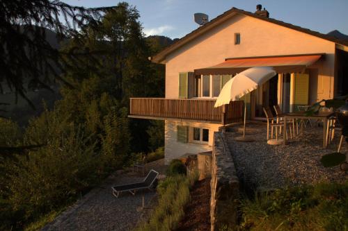 a house with an umbrella and a table and chairs at Gais Alpins in Montreux