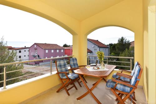 einen Balkon mit einem Tisch und Stühlen sowie Aussicht in der Unterkunft Apartments Ana Vrsi in Vrsi