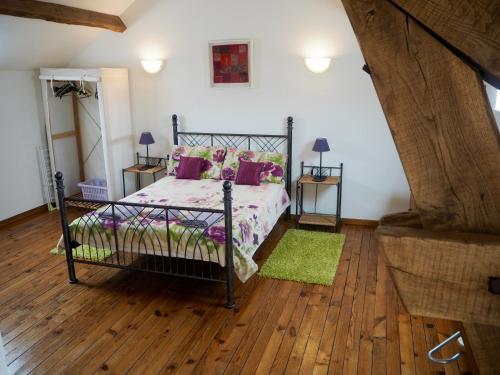 a bedroom with a bed and a wooden floor at Villas de Leypinas Gites in Saint-Pardoux-Corbier